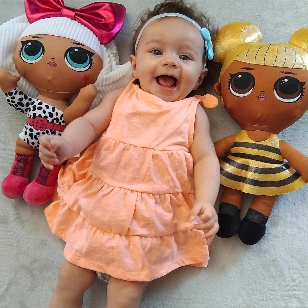 Kamyla a rejoint le concours — aidez-le/la à gagner de superbes lots ! baby, child, colorful, cute, doll, dress, fabric, floor, happy, headband, indoor, infant, large_eyes, lying_down, person, playful, plush, smile, soft, toy