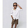 child, boy, sunglasses, white_shirt, khaki_shorts, brown_shoes, fashion, portrait, studio, posing, confident, casual_clothing, standing, cool, young, person, minimalist_background, full_body, summer_outfit, stylish