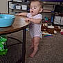 Serenity joined the competition — help win amazing prizes! baby, child, table, bowl, spoon, television, man, glasses, toy, stuffed_animal, carpet, floor, room, shelf, bottle, diapers, furniture, standing, indoor, curious