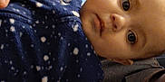 Serenity joined the competition — help win amazing prizes! baby, child, infant, blue_fleece, patterned_clothing, hand, face, eyes, person, portrait, indoor, dark_background, clothing, reaching_hand, young_child, close_up, human, casual_wear, candid, baby_fashion