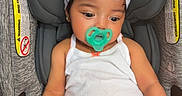 Amira joined the competition — help win amazing prizes! baby, infant, car_seat, pacifier, headband, white_bow, orange_shorts, tank_top, child, cute, seated, indoors, clothing, comfort, safety, young_child, person, portrait, baby_girl, adorable