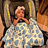 baby, infant, car_seat, blanket, blue, white, cloud_pattern, headband, pink_bow, fist, happy, indoors, wood_floor, child, cute, smiling, small_hands, clothing, person, portrait