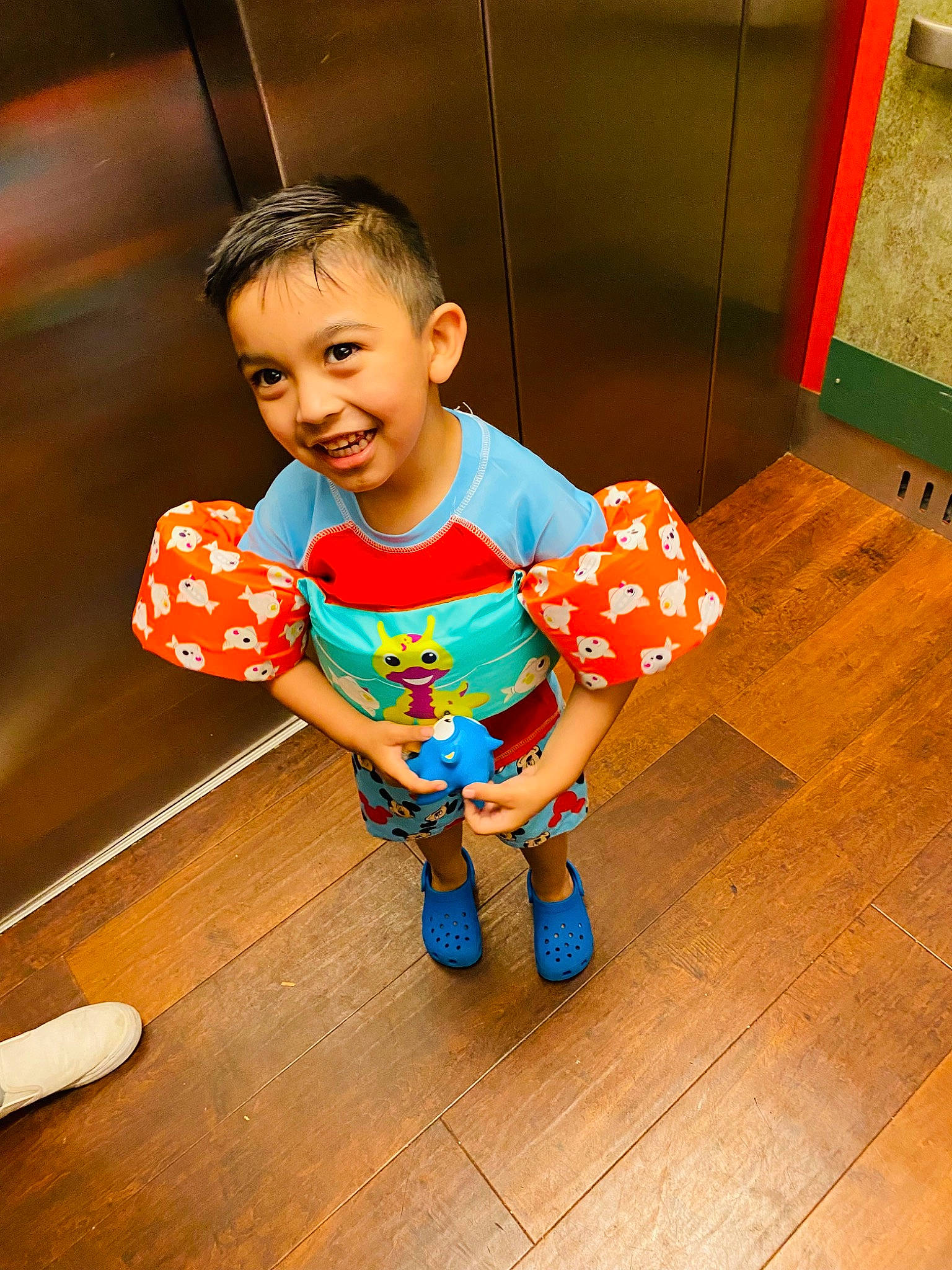 Ethan is registered to the contest to win money with this photo: baby_toddler_clothing, child, design, floor, flooring, fun, happy, hardwood, joy, leisure, pattern, person, play, sitting, sleeve, smile, sock, t_shirt, toddler, varnish