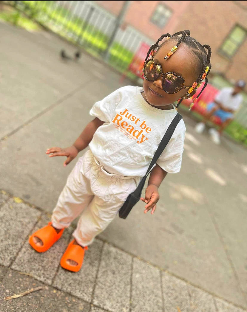 Sylvia joined the competition — help win amazing prizes! asphalt, child, eyewear, foot, footwear, fun, happy, human_leg, leisure, orange, person, plant, recreation, road, sandal, sidewalk, sleeve, smile, street_fashion, t_shirt