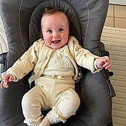 Luna a rejoint le concours — aidez-le/la à gagner de superbes lots ! baby, infant, smiling, sitting, baby_bouncer, cardigan, onesie, socks, happy, cute, indoor, carpet, tile_floor, seat, face, hands, blue_eyes, rosy_cheeks, portrait, fabric_texture