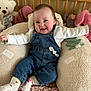 baby, infant, smile, denim_overalls, socks, stuffed_toy, teddy_bear, crib, bedding, plush_toy, portrait, rosy_cheeks, happy, arms_outstretched, indoor, child, cute, cushion, seated, soft_texture