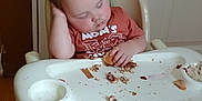Adriel joined the competition — help win amazing prizes! baby, toddler, high_chair, sleeping, messy_hair, food_crumbs, snack, indoor, wood_floor, plastic_chair, child, casual, messy, clothing, face, hand, foot, wooden_door, tray, furniture
