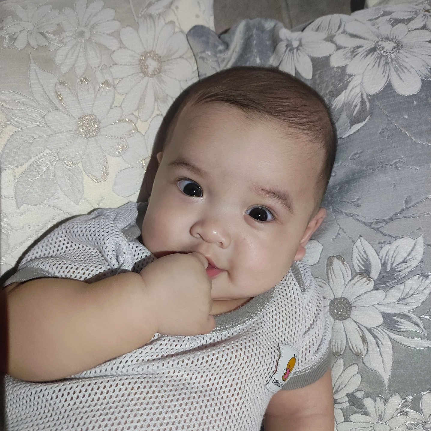 Ulya is registered to the contest to win money with this photo: baby, child, clothing, comfort, couch, cute, expression, face, floral, hand, indoor, infant, mesh_shirt, pattern, person, pillow, portrait, relaxing, skin, young