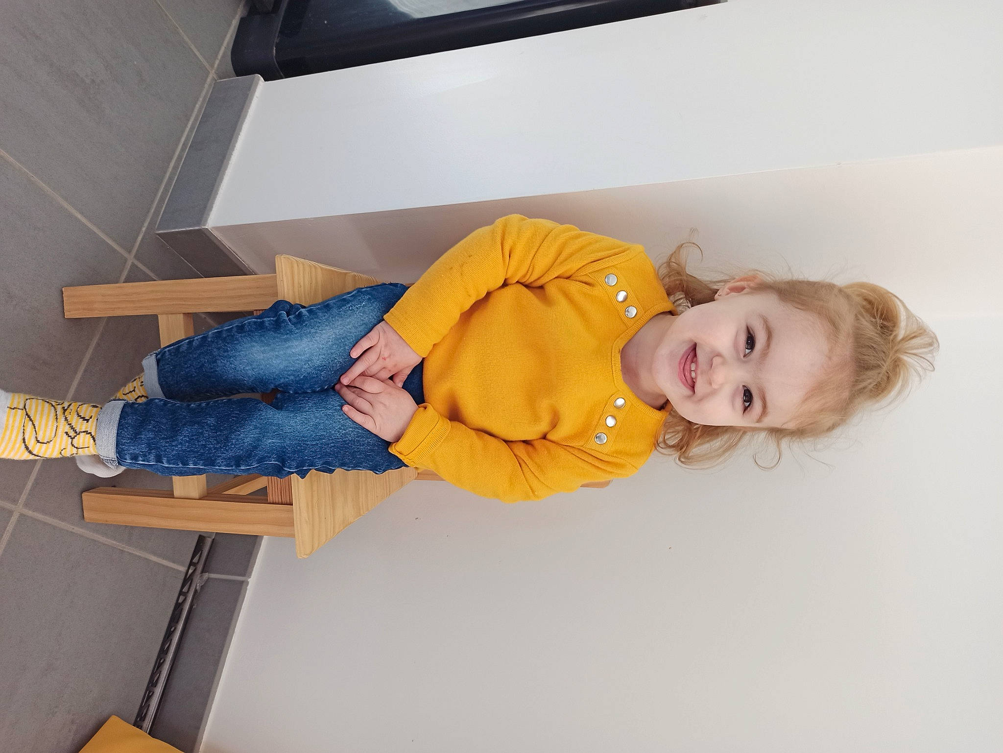 Judite participe au concours pour gagner de l'argent avec cette photo : baby_toddler_clothing, comfort, couch, denim, elbow, flooring, home_appliance, human_leg, joy, knee, leg, linens, person, room, sandal, sitting, sleeve, smile, thigh, toddler