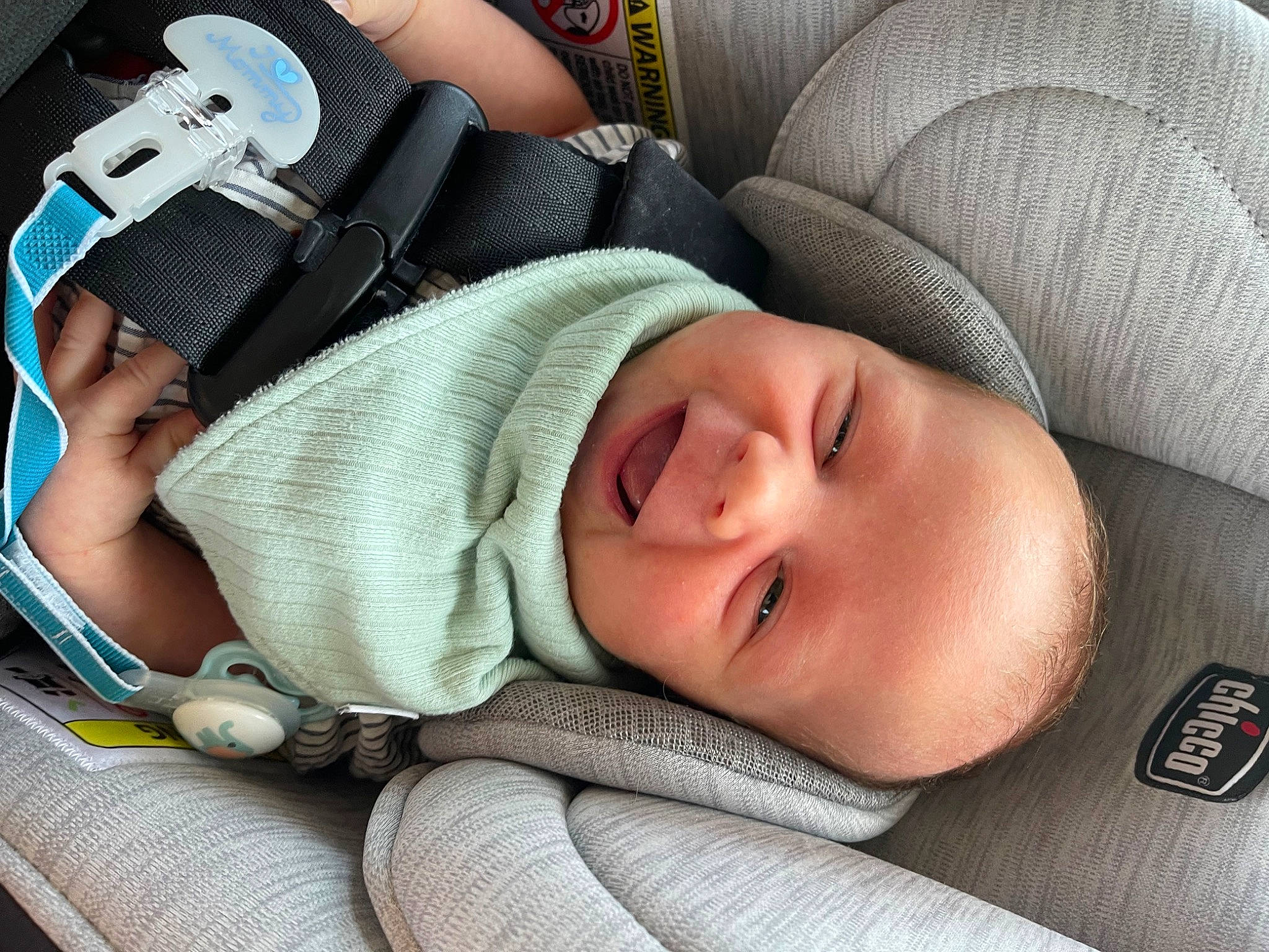 Logan is registered to the contest to win money with this photo: auto_part, baby, baby_carriage, baby_products, baby_sleeping, baby_toddler_clothing, bag, car_seat, cheek, child, comfort, eyelash, finger, linens, nail, nap, person, sitting, skin, toddler