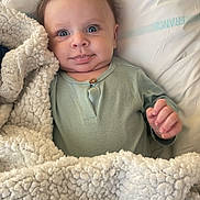 Milan participe au concours pour gagner de l'argent avec cette photo : baby, infant, blanket, pillow, blue_eyes, clothing, face, hand, sleepwear, cute, lying_down, soft_texture, indoors, portrait, child, newborn, expression, warm, comfort, resting