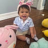baby, bunny_ears, headband, smile, happy, child, toy, stuffed_animal, floor, wooden_floor, indoor, shorts, shirt, socks, door, wall, playtime, cute, infant, candid