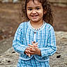 child, smiling, girl, curly_hair, bow, pearl_necklace, blue_outfit, checkered, outdoor, rock, nature, portrait, happy, cute, fashion, sitting, young, person, casual, daylight