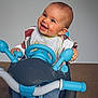 ézia participe au concours pour gagner de l'argent avec cette photo : baby, bib, blue_toy, casual_clothing, child, cute, fun, hands_on_toy, happy, indoor, infant, jeans, neutral_background, orange_socks, playtime, portrait, seated, short_hair, smiling, toy_motorcycle