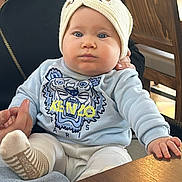 Ambre participe au concours pour gagner de l'argent avec cette photo : adult_hand, baby, beanie, blue_eyes, child, cute, hat, indoor, infant, kenzo_logo, menu, person, portrait, restaurant, sitting, sock, sweater, table, tiger_patch, wooden_chair