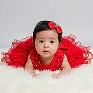 Alice joined the competition — help win amazing prizes! baby, child, red_dress, bow, cute, portrait, infant, fluffy, white_background, face, adorable, fashion, tutu, lying_down, young_child, studio_photo, black_hair, looking_at_camera, decorative_clothing, soft_texture