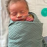newborn, baby, sleeping, hospital, bassinet, blanket, swaddled, infant, face, closed_eyes, bedhead, oxygen_tube, medical, pillow, bed, peaceful, portrait, indoors, mint_green, resting
