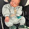 newborn, baby, infant, sleeping, car_seat, pajamas, dinosaur_slippers, pacifier, necklace, mint_green, clothing, portrait, face, closed_eyes, indoors, travel, safety_harness, seated, cute, resting