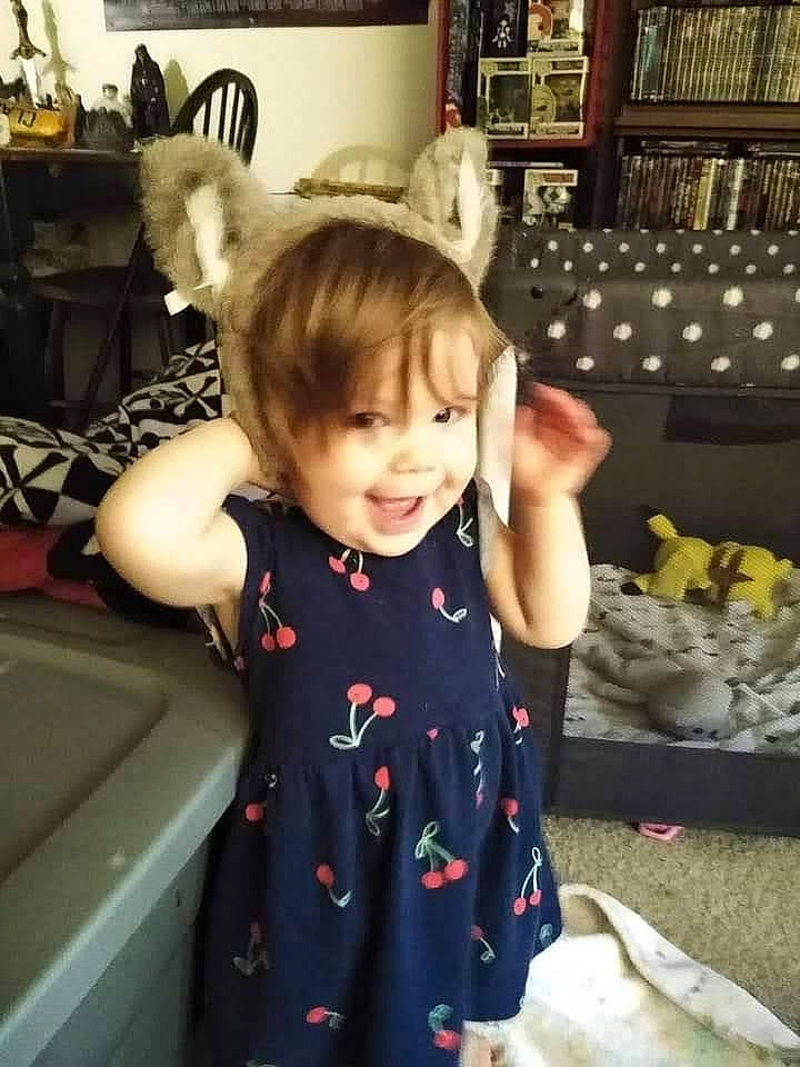 Lydia is registered to the contest to win money with this photo: baby, baby_toddler_clothing, chair, child, fun, fur, happy, kitchen, pattern, person, picture_frame, room, shelf, sitting, sleeve, smile, standing, t_shirt, thumb, toddler