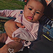 Xaila is registered to the contest to win money with this photo: baby, child, infant, holding, pink_clothing, outdoor, daylight, grass, car, suburban, person, hand, blanket, pacifier, face, expression, portrait, sunlight, nature, casual