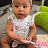 baby, infant, headband, sitting, curious, indoors, clothing, pink, hello_kitty, blanket, toy, cute, child, person, face, expression, hand, feet, bedroom, soft_toy