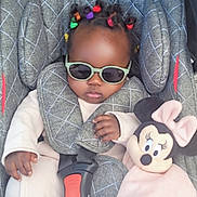 Halya participe au concours pour gagner de l'argent avec cette photo : accessory, baby, baby_clothes, car_seat, child, clothing, colorful_hair_ties, cute, fashionable, indoors, infant, minnie_mouse, person, plush_toy, portrait, relaxed, seat_belt, small_child, soft_toy, sunglasses