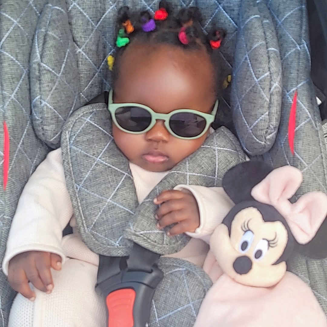 Halya participe au concours pour gagner de l'argent avec cette photo : accessory, baby, baby_clothes, car_seat, child, clothing, colorful_hair_ties, cute, fashionable, indoors, infant, minnie_mouse, person, plush_toy, portrait, relaxed, seat_belt, small_child, soft_toy, sunglasses