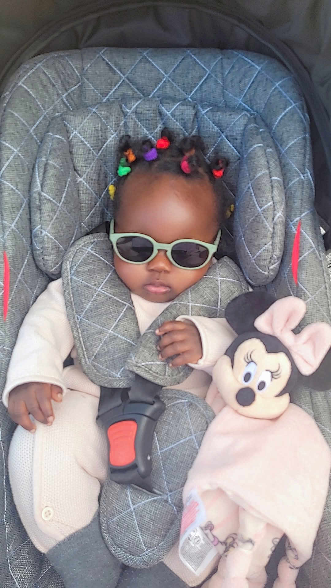 Halya participe au concours pour gagner de l'argent avec cette photo : accessory, baby, baby_clothes, car_seat, child, clothing, colorful_hair_ties, cute, fashionable, indoors, infant, minnie_mouse, person, plush_toy, portrait, relaxed, seat_belt, small_child, soft_toy, sunglasses