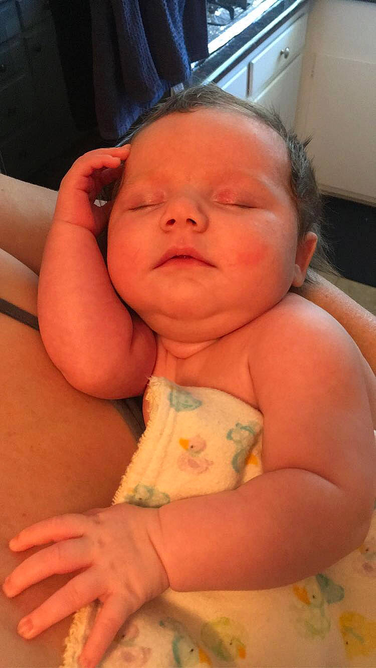 Suzannah is registered to the contest to win money with this photo: baby, baby_toddler_clothing, cheek, chest, comfort, eye, eyebrow, finger, happy, linens, lip, mouth, neck, nose, person, pink, skin, smile, stomach, thumb