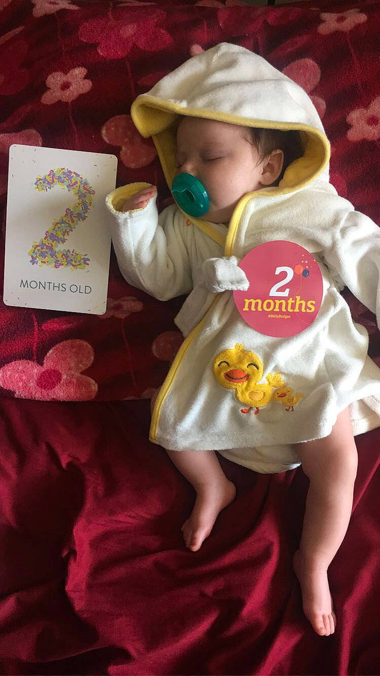 Suzannah is registered to the contest to win money with this photo: baby, baby_toddler_clothing, cap, child, costume, event, fictional_character, font, happy, hat, headgear, linens, magenta, peach, person, pink, room, sleeve, sun_hat, toddler