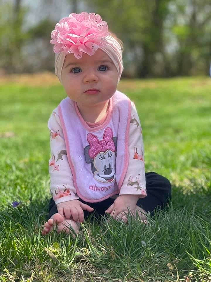 Emberlyn is registered to the contest to win money with this photo: baby, baby_toddler_clothing, cap, child, facial_expression, finger, fun, grass, grassland, happy, head, headpiece, headwear, lip, meadow, people_in_nature, person, pink, plant, skin