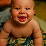 arms, baby, bare_chested, bright_eyes, child, closeup, crawling, cute, expression, face, floral_blanket, happy, indoors, infant, person, playful, portrait, skin, smiling, young_child