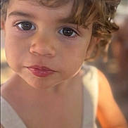 Andrea a rejoint le concours — aidez-le/la à gagner de superbes lots ! child, toddler, face, big_eyes, curly_hair, portrait, close_up, lips, skin, sleeveless_dress, candid, bokeh_background, natural_light, expressive_face, headshot, preschooler, innocence, brown_hair, soft_focus, warm_tone