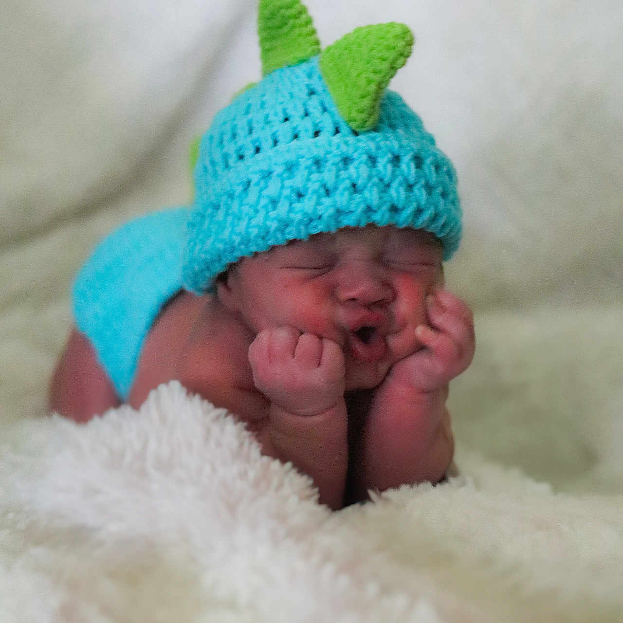 Zander is registered to the contest to win money with this photo: adorable, baby, blanket, blue_hat, child, close_up, cozy, cute_face, green_spikes, indoors, infant, knit_hat, newborn, portrait, puckered_lips, resting, sleepy, soft_texture, tiny_hands, warm