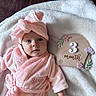 baby, baby_sign, blanket, child, eyes, face, flowers, fluffy, indoor, infant, lying_down, milestone, photography, pink, portrait, robe, smiling, three_months, towel, wood_floor