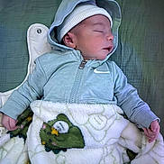 Gabin participe au concours pour gagner de l'argent avec cette photo : baby, sleeping, hoodie, hat, blanket, frog_pattern, cozy, infant, child, sleep, soft, cute, clothing, zipped_jacket, lying_down, hand, face, peaceful, warm, resting
