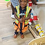 Paityn Williams joined the competition — help win amazing prizes! axe, boy, child, clothing, device, face, footwear, hardhat, head, helmet, male, person, photography, plywood, portrait, shoe, tool, vest, wood, worker