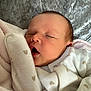 Ivy-Leigh is registered to the contest to win money with this photo: baby, newborn, sleeping, yawning, blanket, soft_texture, clothing, infant, cute, face, peaceful, resting, indoors, portrait, cozy, warm, skin, head, hand, fabric