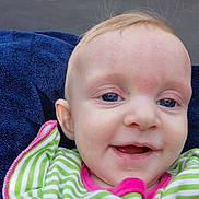 Olivia is registered to the contest to win money with this photo: baby, infant, close_up, drooling, smiling, blue_eyes, navy_towel, blanket, striped_clothing, green_and_white, face, ear, forehead, portrait, candid, outdoor, clothing, happy, mouth, eye_contact