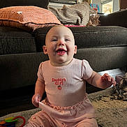 Briar joined the competition — help win amazing prizes! baby, child, smiling, pink_clothing, sitting, indoor, couch, toy, carpet, home, cute, happy, infant, person, furniture, floor, girl, playtime, room, portrait