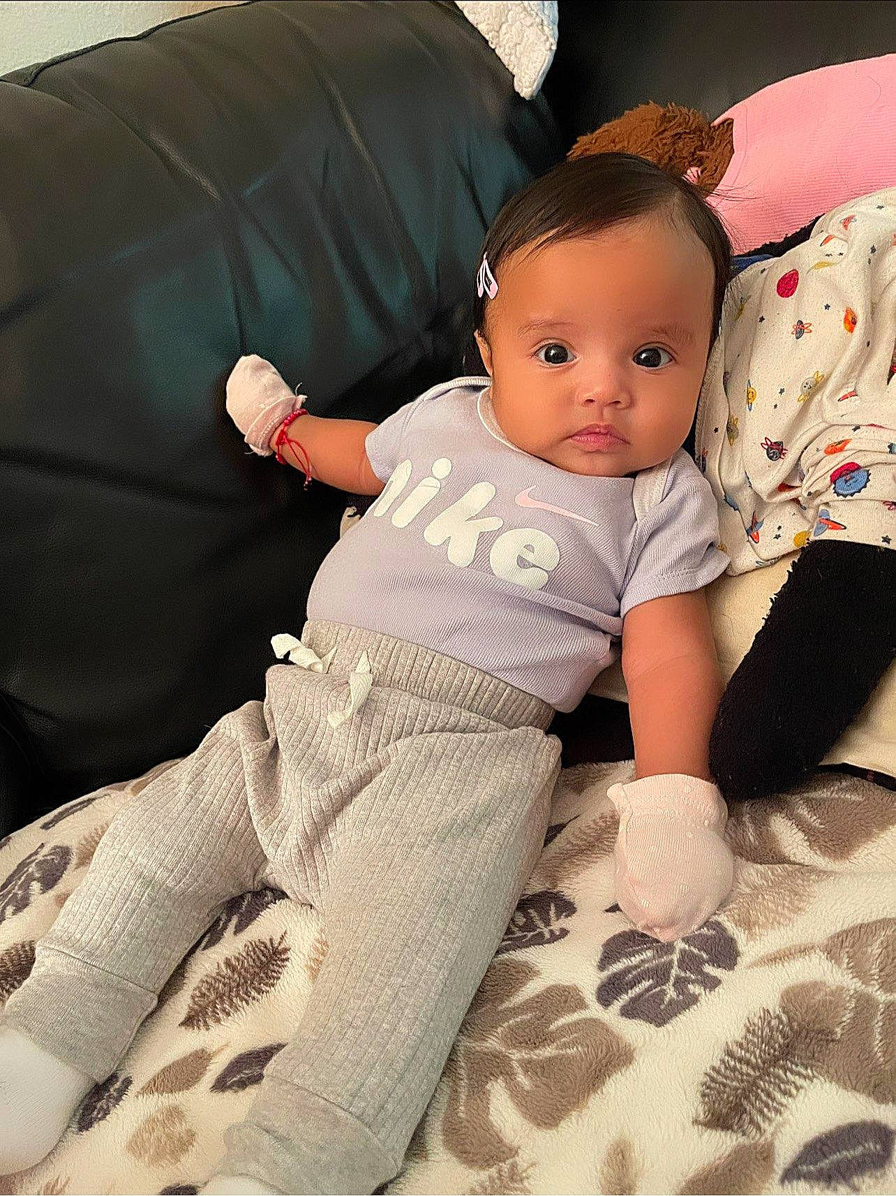 Angelina joined the competition — help win amazing prizes! baby, baby_toddler_clothing, barefoot, child, comfort, couch, flooring, foot, happy, human_leg, knee, lap, linens, pattern, person, sitting, sleeve, sock, thigh, toddler