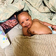 Josiah joined the competition — help win amazing prizes! baby, infant, blanket, bed, bottle, diaper, face, person, skin, cute, resting, indoors, furniture, sleepwear, comfort, child, portrait, young, relaxation, cozy