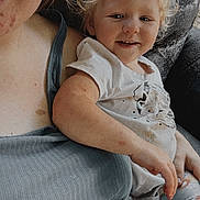 Oakleigh is registered to the contest to win money with this photo: toddler, child, person, smiling, blond_hair, casual_clothing, sitting, adult, lap, portrait, indoor, skin, freckles, short_sleeves, patterned_pants, texture, relaxed, happy, close_up, family