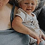 adult, blond_hair, casual_clothing, child, close_up, family, freckles, happy, indoor, lap, patterned_pants, person, portrait, relaxed, short_sleeves, sitting, skin, smiling, texture, toddler