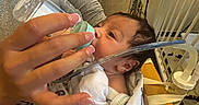 Amore joined the competition — help win amazing prizes! baby, newborn, bottle, feeding, hospital, blanket, person, hand, medical_equipment, bed, nail_polish, infant, healthcare, care, wrapped, closeup, indoors, tubing, resting, patient
