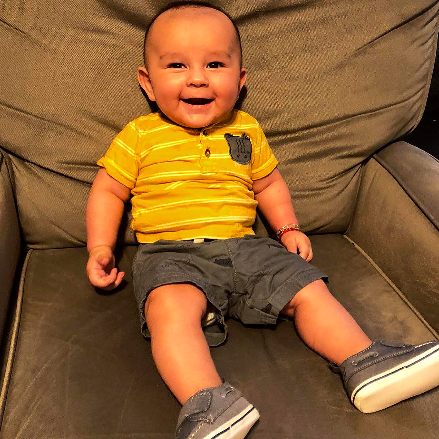 Everardo is registered to the contest to win money with this photo: baby, baby_toddler_clothing, cheek, child, comfort, couch, fun, happy, human, human_body, human_leg, joy, knee, person, shorts, sitting, skin, sleeve, smile, t_shirt