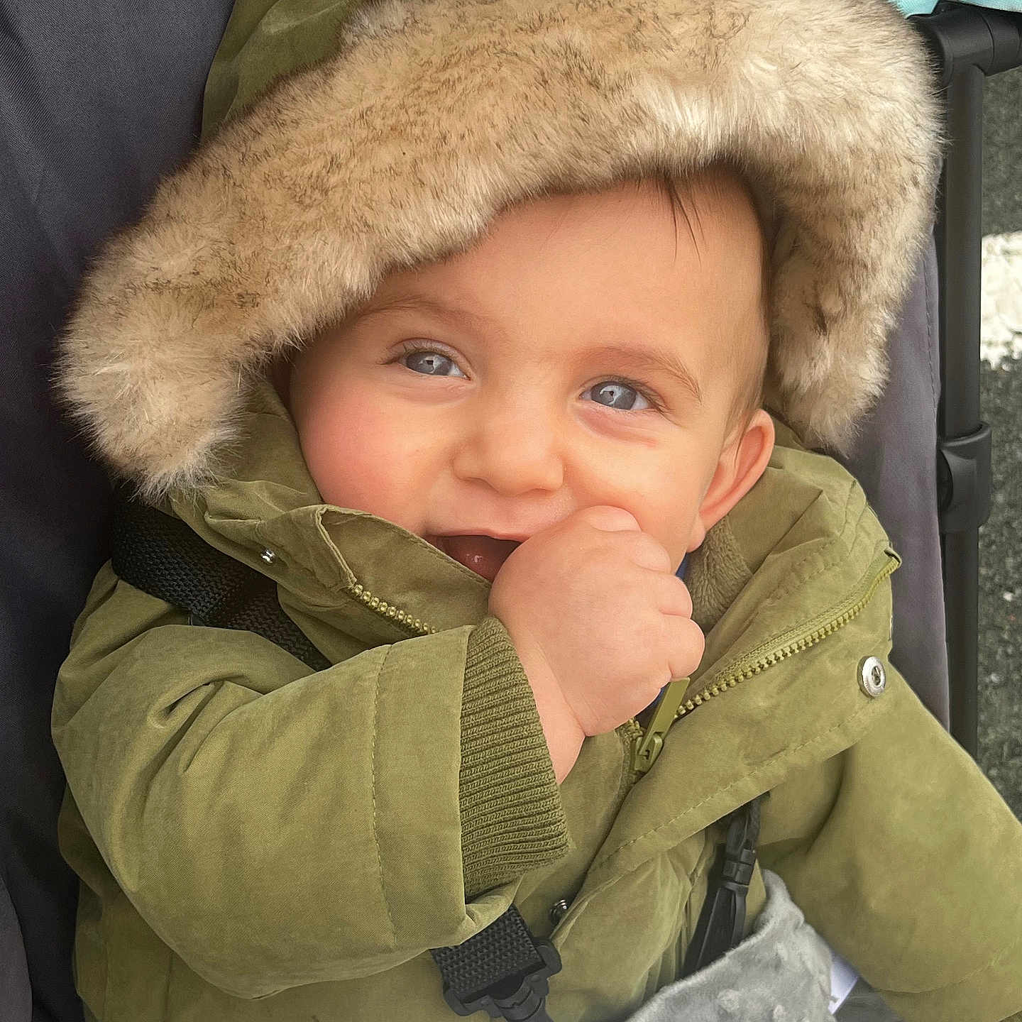 Killyan participe au concours pour gagner de l'argent avec cette photo : baby, baby_hand, blanket, blue_eyes, child, closeup, cold_weather, cute, face, fur_hood, green_jacket, happy, hooded_jacket, infant, outdoor, person, portrait, smiling, stroller, warm_clothing