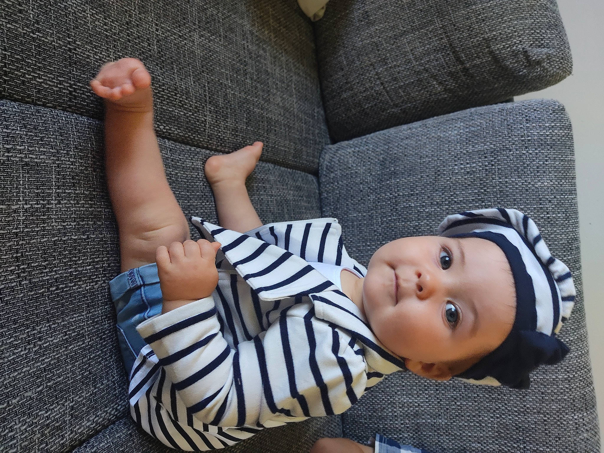 Kessy a rejoint le concours — aidez-le/la à gagner de superbes lots ! baby_toddler_clothing, child, comfort, couch, design, finger, grass, grey, headgear, headwear, human_leg, joint, knee, linens, pattern, person, sitting, sleeve, textile, thigh