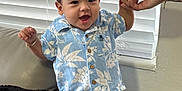 Liam Matías joined the competition — help win amazing prizes! toddler, child, smiling, blue_clothing, floral_pattern, standing, couch, indoor, hand_holding, adult_hand, happy, cute, portrait, window_blinds, home, jewelry, shorts, shirt, person, young_child
