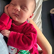 Gabriel participe au concours pour gagner de l'argent avec cette photo : baby, sleeping, infant, red_clothing, christmas_outfit, santa_claus, christmas_tree, hand, arm, bed, blanket, resting, peaceful, cute, portrait, indoors, newborn, soft_light, comfort, cozy